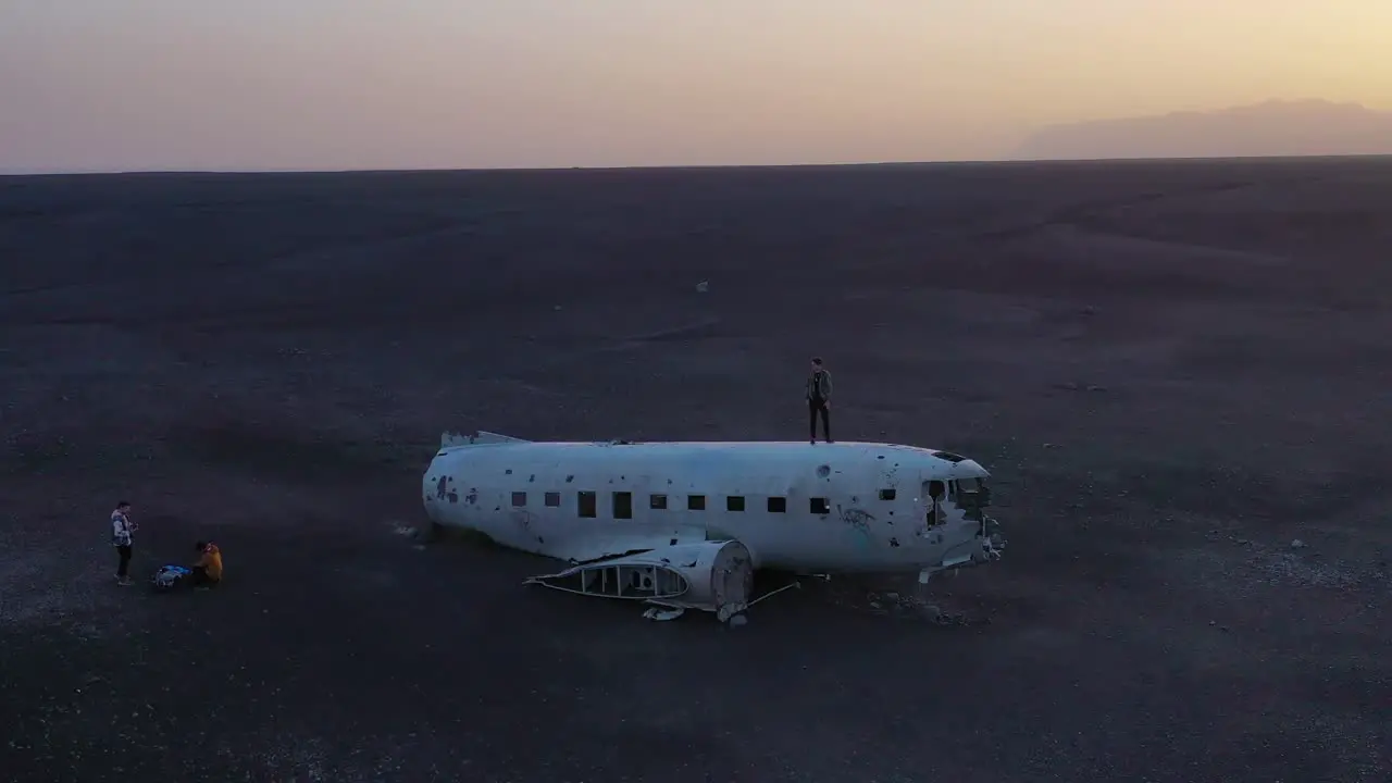 Aerial man standing on a crashed US Navy DC-3 on the black sands of Solheimasandur Iceland 2