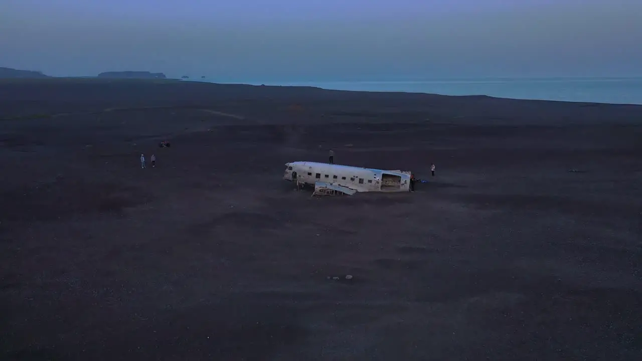 Aerial man standing on a crashed US Navy DC-3 on the black sands of Solheimasandur Iceland 3