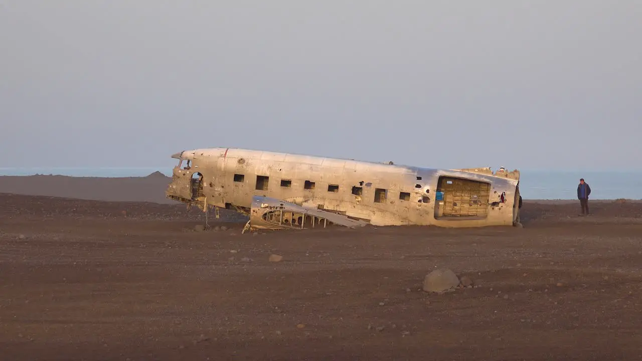 Tourists inspect a crashed US Navy DC-3 on the black sands of Solheimasandur Iceland