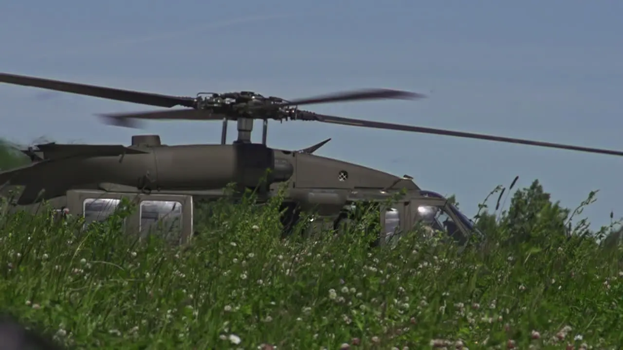 Sikorsky UH-60 Black Hawk Taxiing Past Tall Grass With Main Rotor Blades Spinning