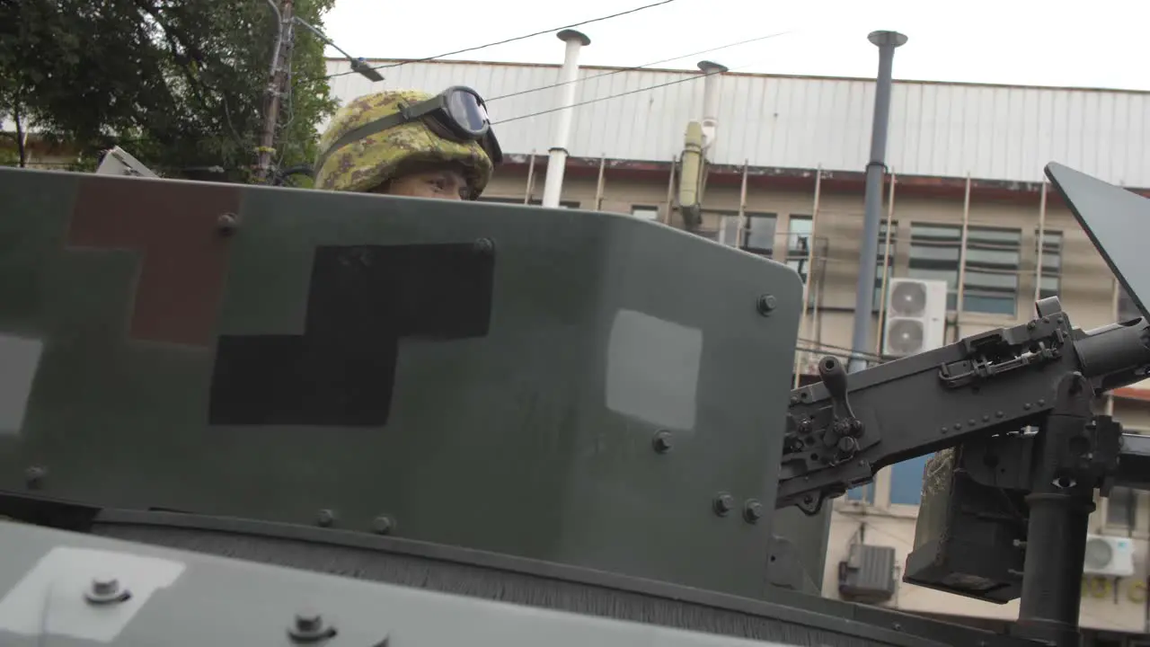 Soldier operates turret in a military armored vehicles parade along the streets of the city of San Salvador during the country's independence day celebration