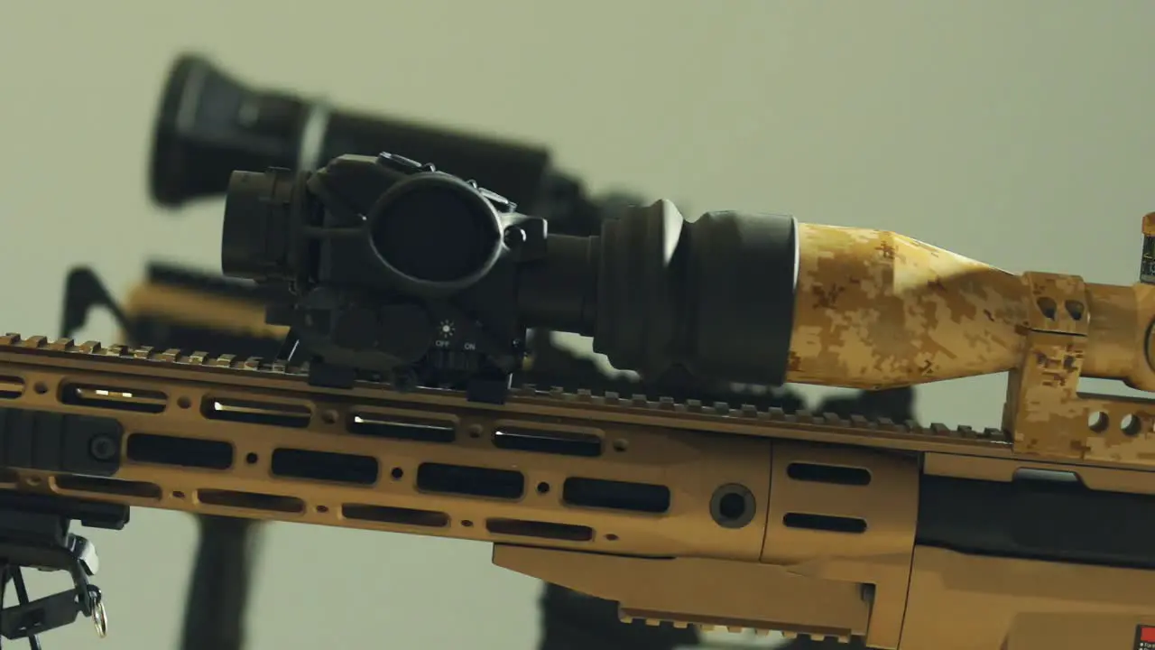 Black scope on top of a beige army tinted rifle