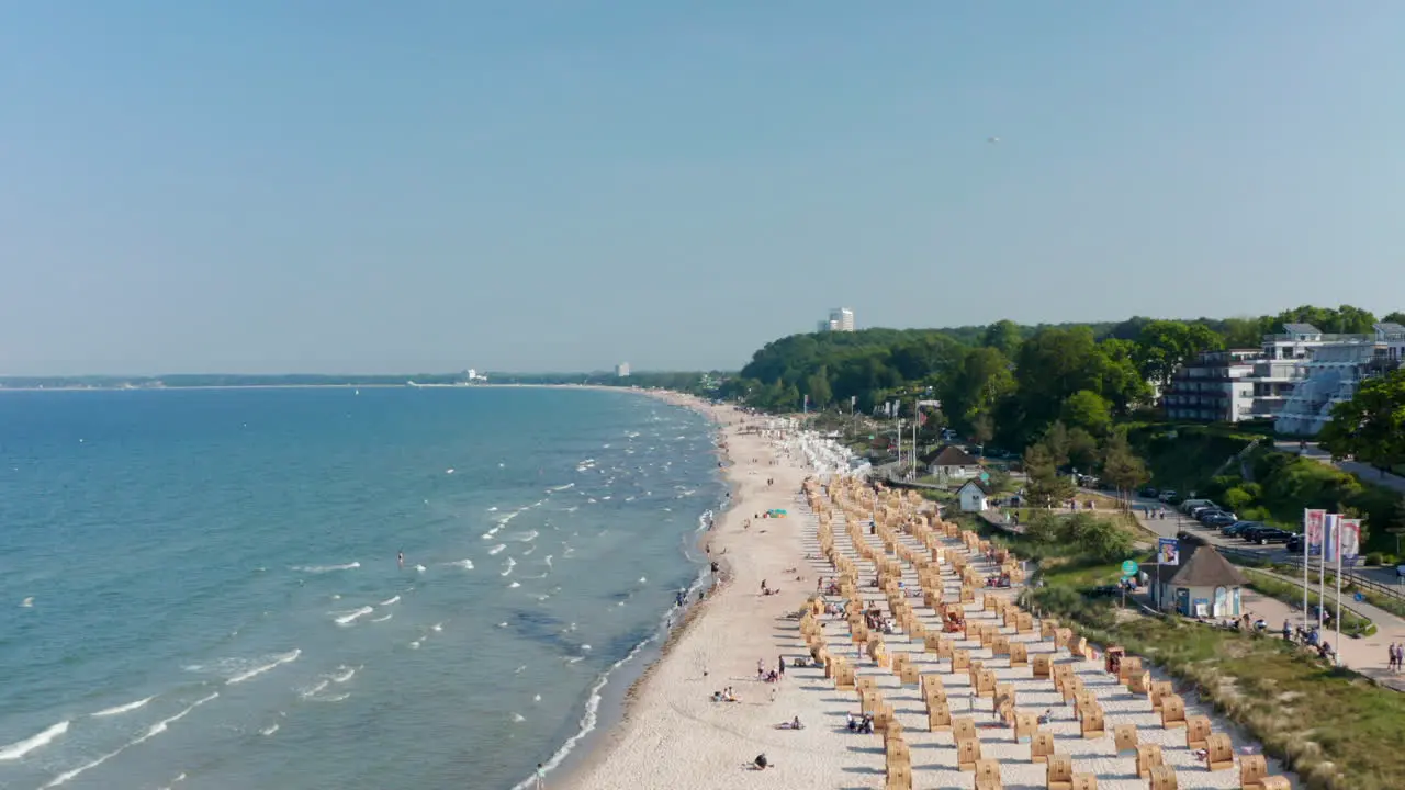 Summertime baltic beach in Scharbeutz Germany with beach chairs and tourists on sand forward day