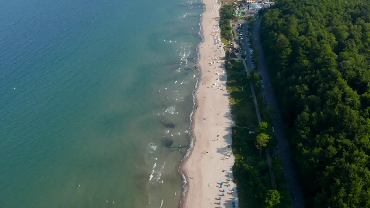 Amazing aerial drone flying above tourist Baltic sea beach in Scharbeutz Germany dolly in day