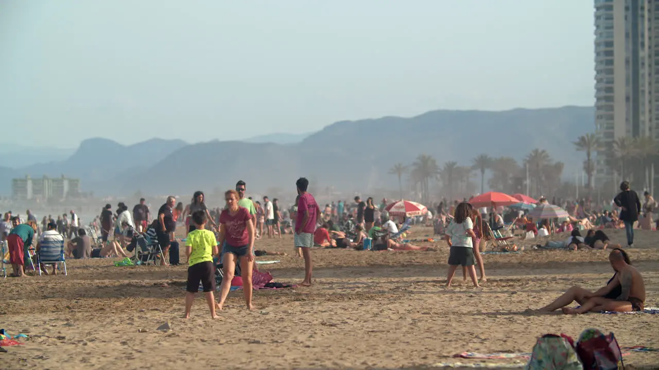 Scenic beach full of people relaxing and playing tennis