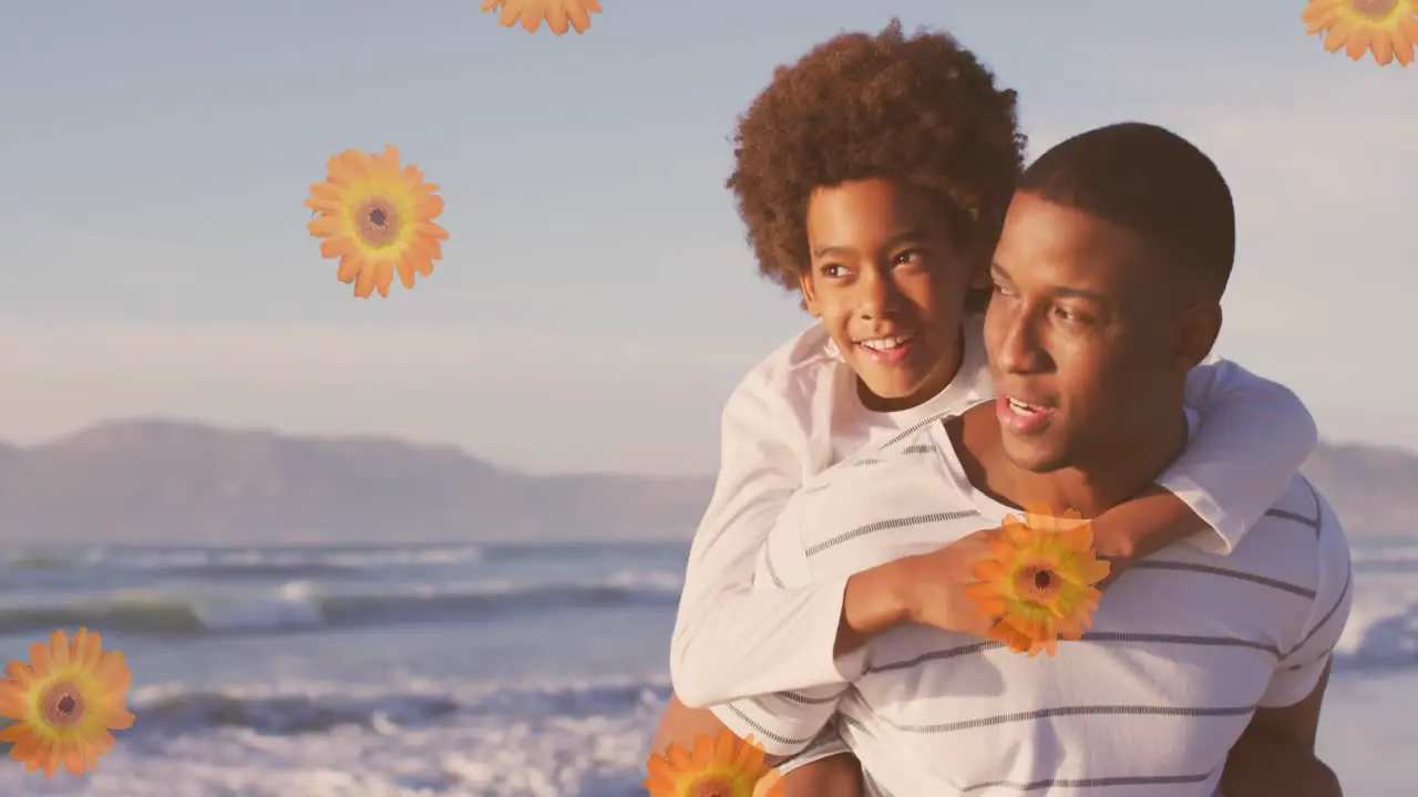 Animation of flowers over happy african american father with son on sunny beach