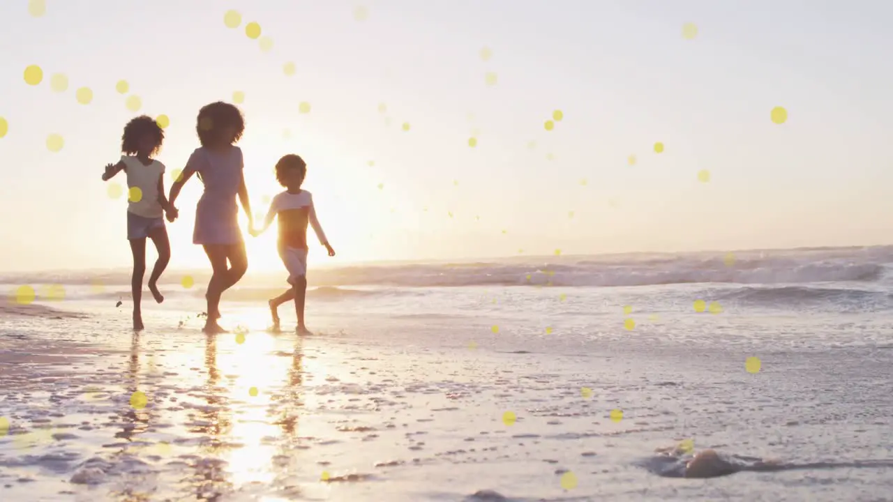 Animation of spots over happy african american mother with children on sunny beach