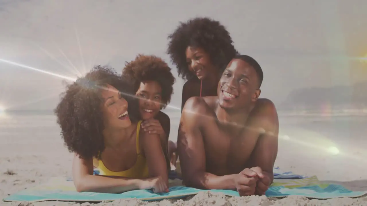 Animation of light sptos over happy african american family lying on sunny beach