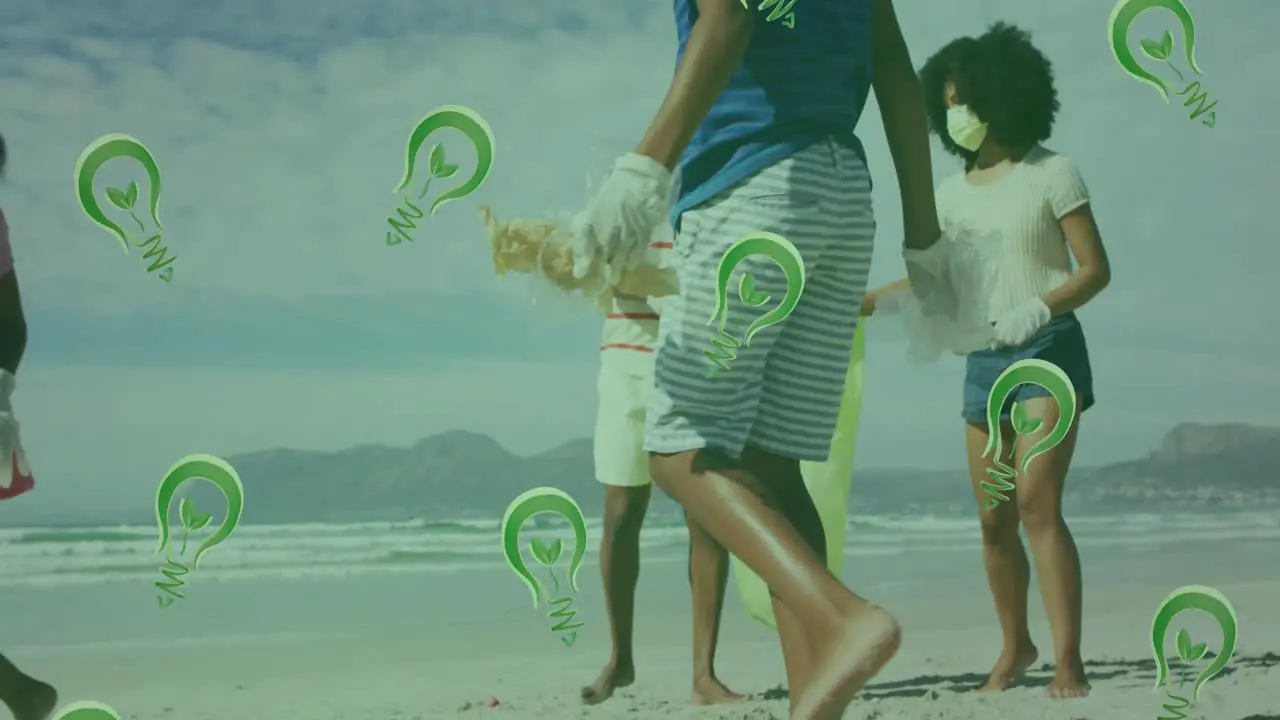 Animation of lightbulbs over happy african american family picking waste on sunny beach