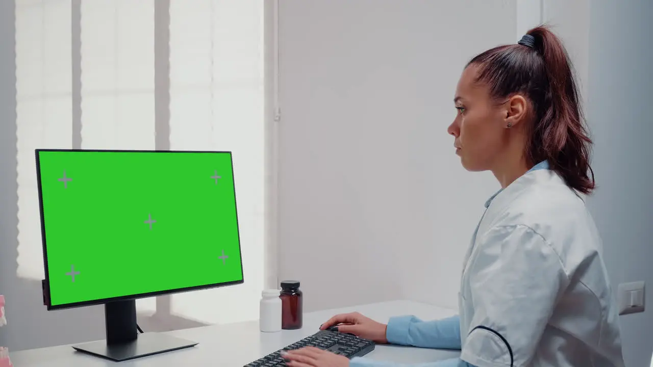 Dentist working with horizontal green screen on computer