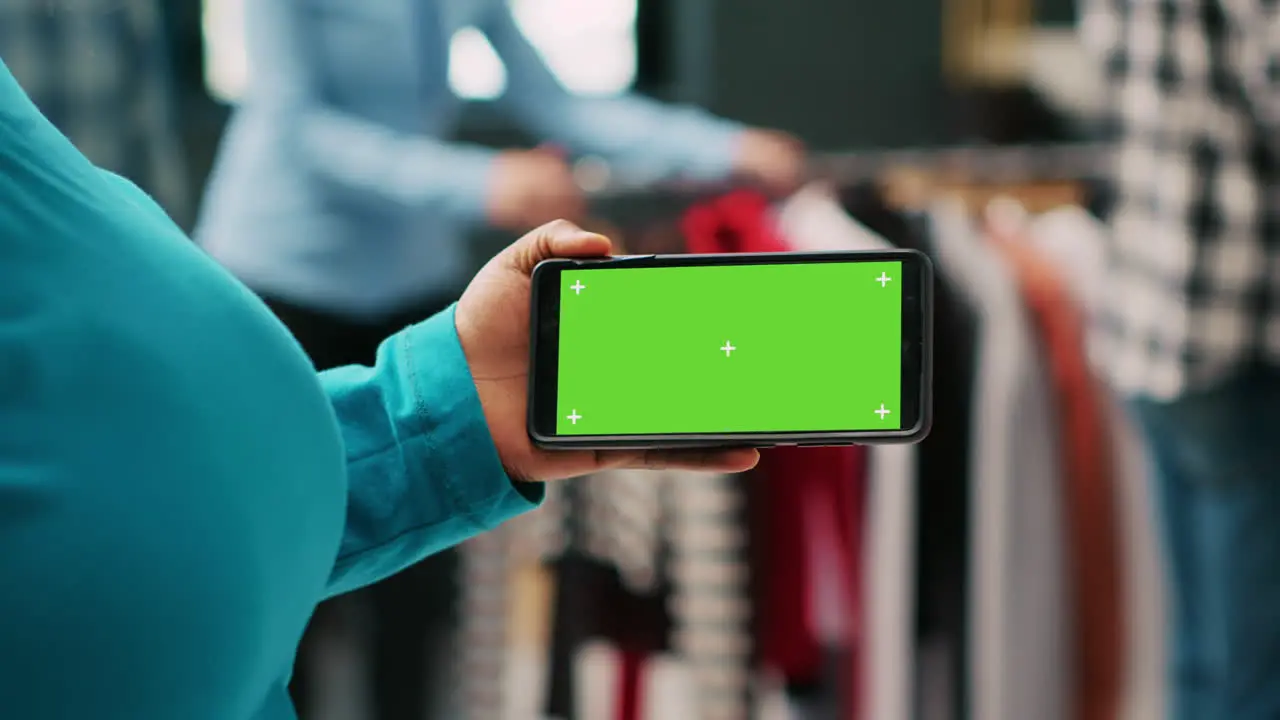 Client looking at phone with greenscreen