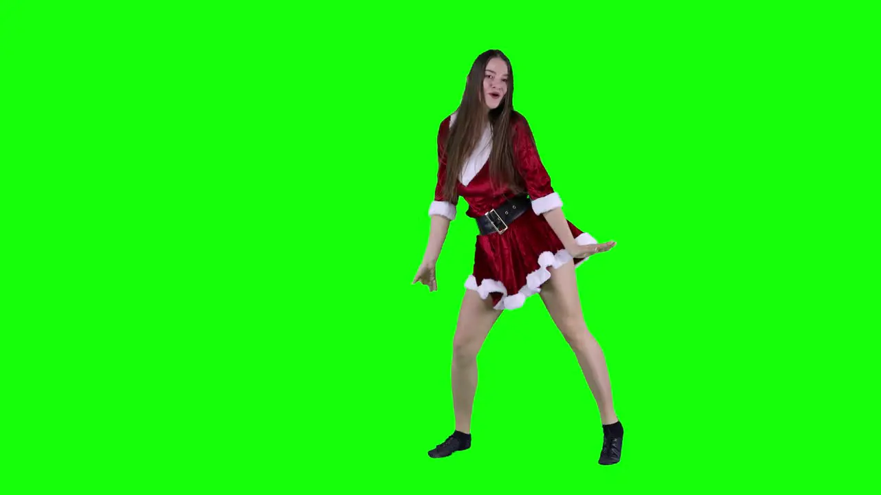 Caucasian American woman celebrating Christmas dancing video in front of the green screen