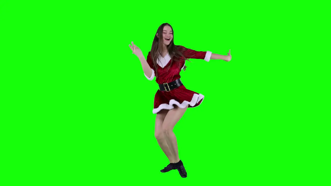 Talented and beautiful female dancer dancing in front of a green screen wearing Christmas Santa dress