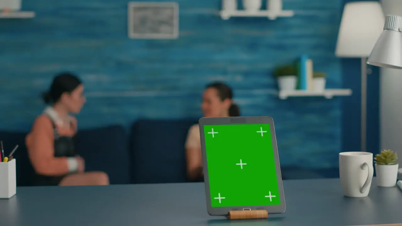 Isolated tablet computer with mock up green screen chroma key standing on desk table