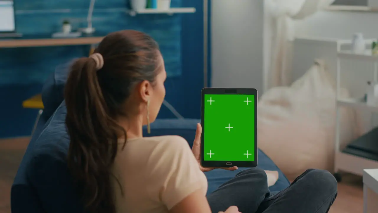 Business woman looking at tablet computer with mock up green screen chroma key display