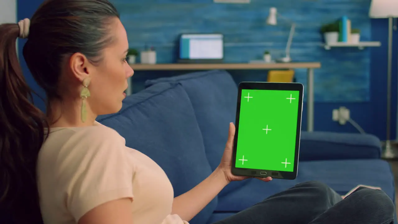 Freelancer woman looking at green mock up screen tablet computer