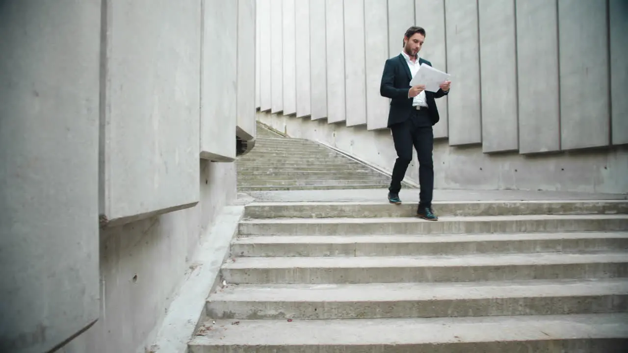 Business man looking at documents on street Male executive walking for meeting