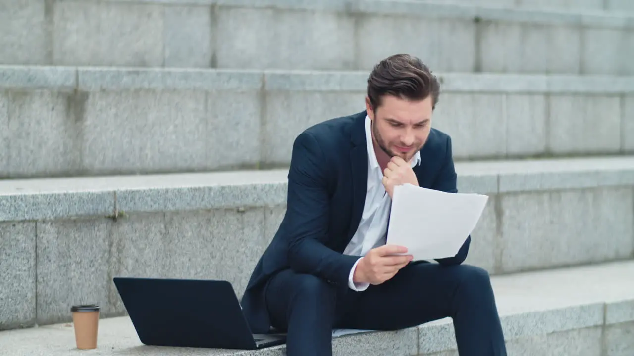 Business man looking at papers on street Executive thinking about graphs