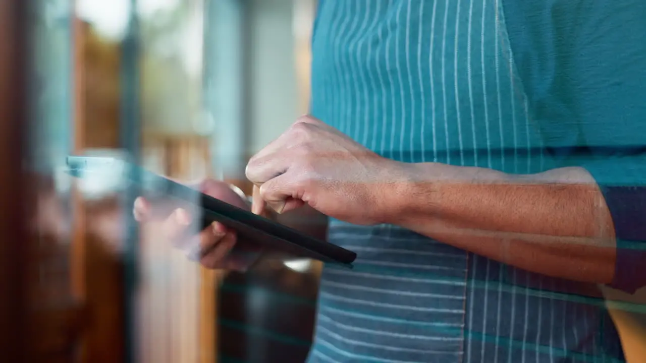 Hands tablet and a waiter in a coffee shop