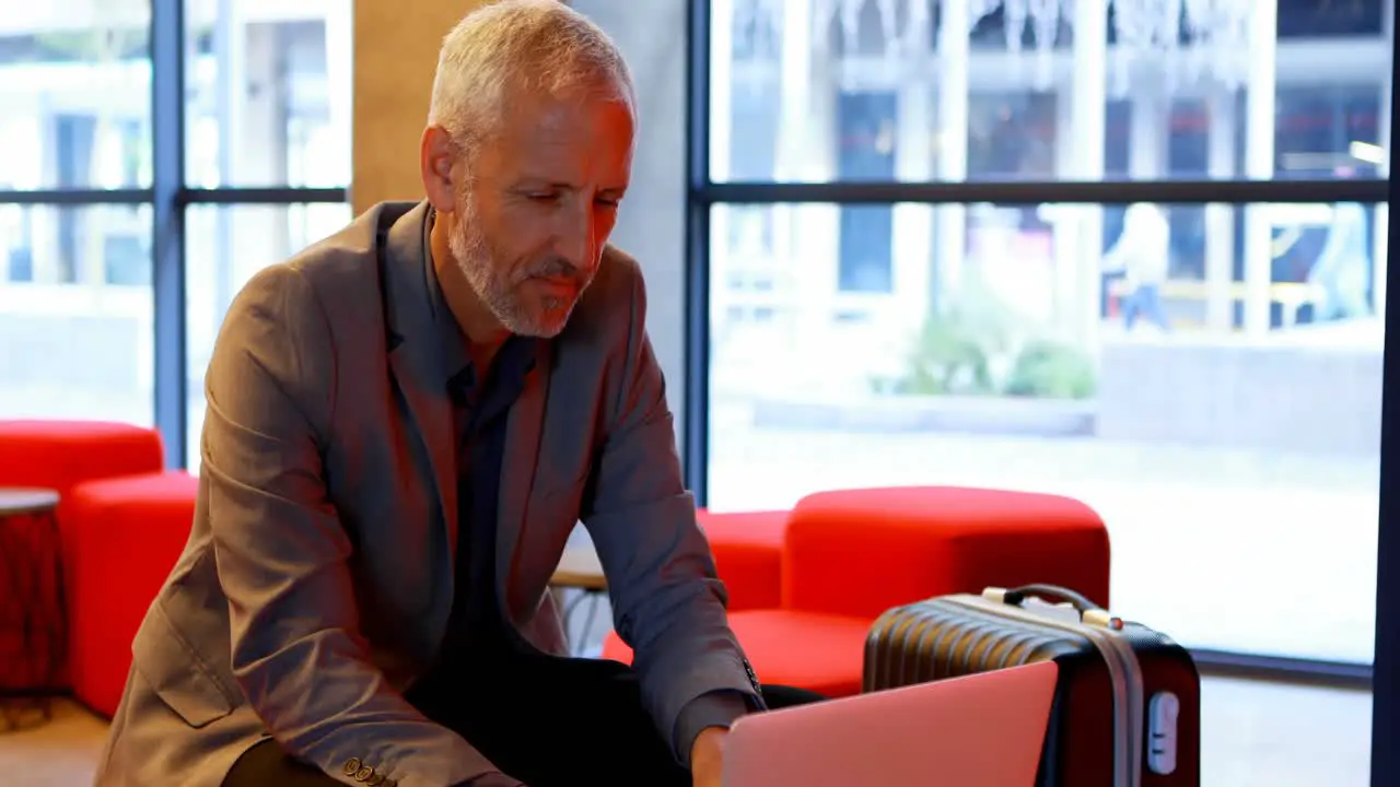 Businessman using laptop in hotel lobby 4k