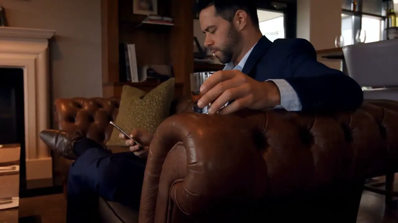 Businessman using mobile phone on sofa 4k