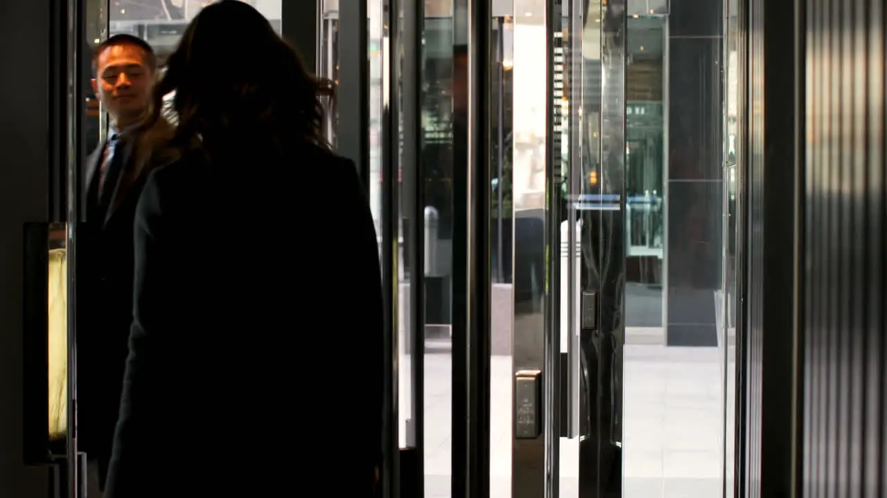 Rear view of businesswoman leaving hotel with luggage 4k