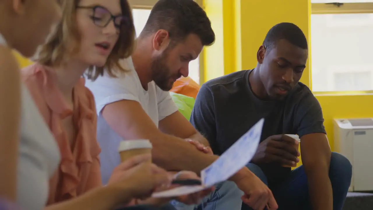 Young mixed race business team discussing over document in modern office 4k