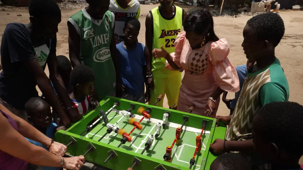 A white woman plays table football against a black woman in a neighborhood of Nouakchott Mauritania