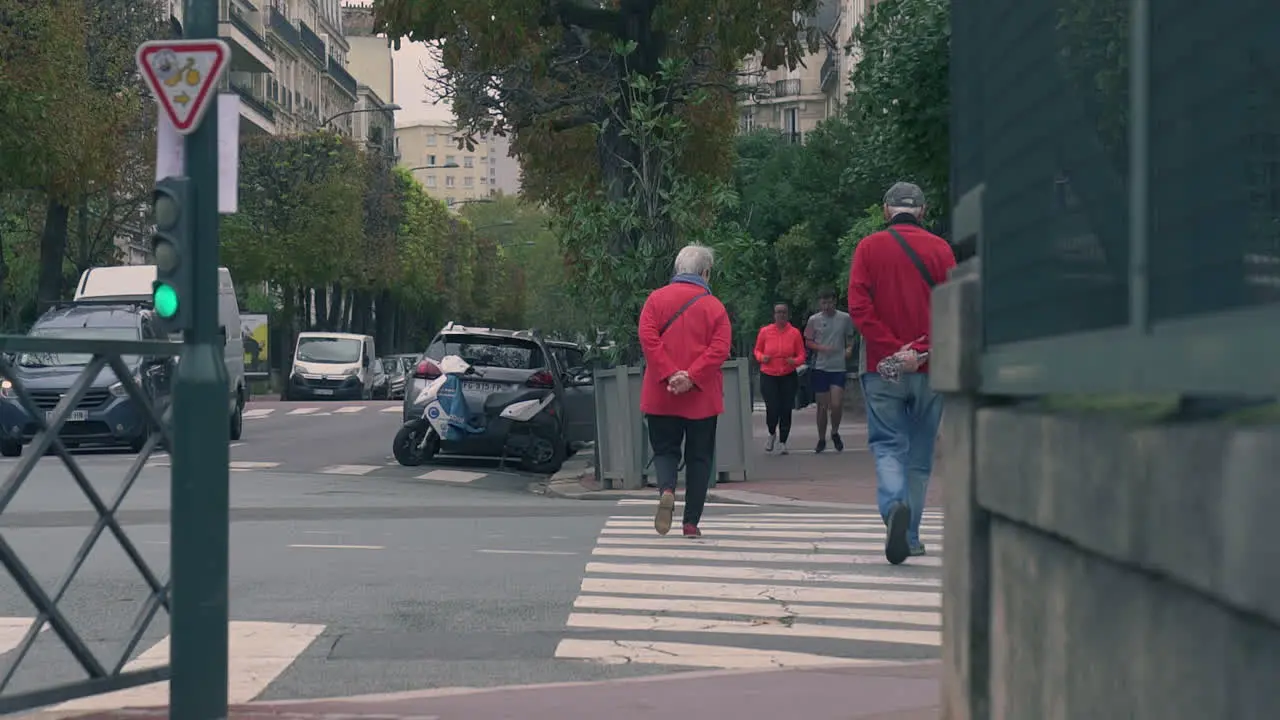 Elderly Couple Crossing A Street In Suburban Neighborhood