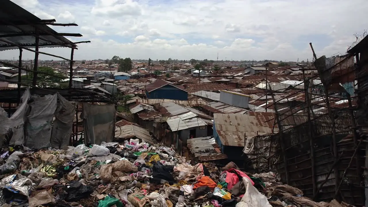 Big pile of trash and view of Kibera's tin roofs