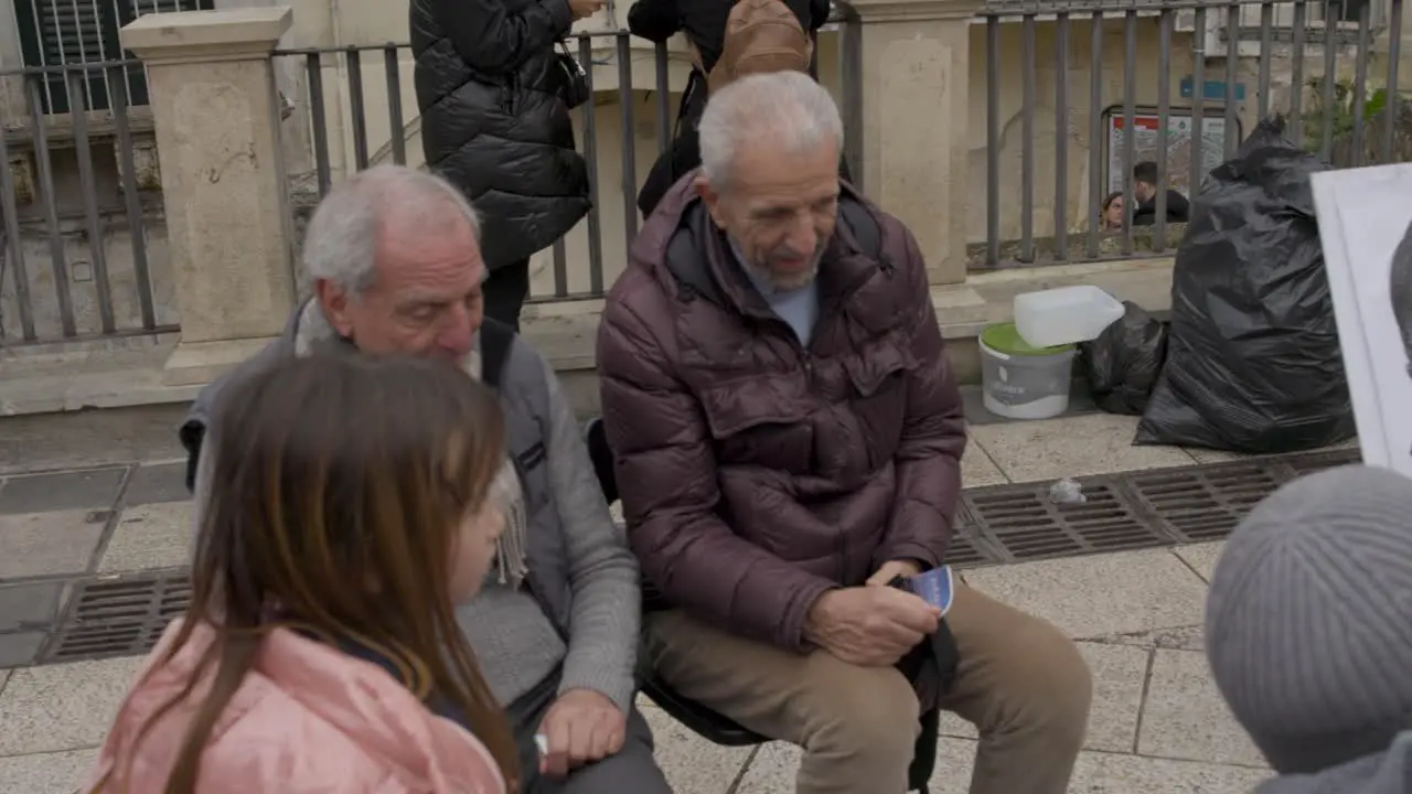 Two Men in Matera Italy having their picture drawn on the street