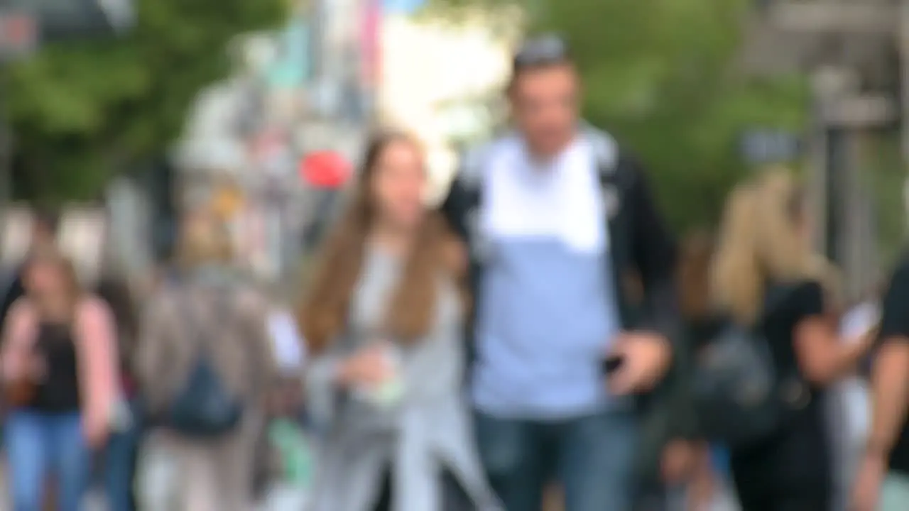 Slow motion of defocused commuters walking to work or shopping footage of blurred unrecognizable people busy city life