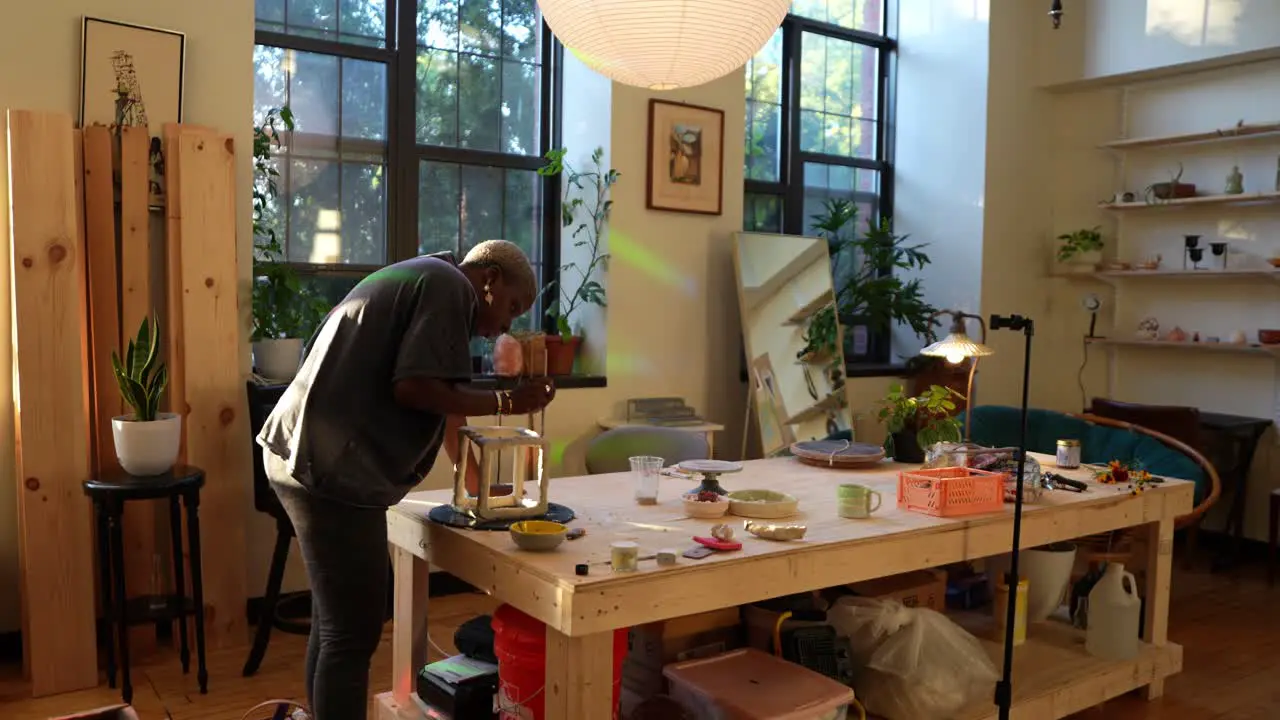 4k 60fps An african american artist sculpting a clay box in her studio during golden hour