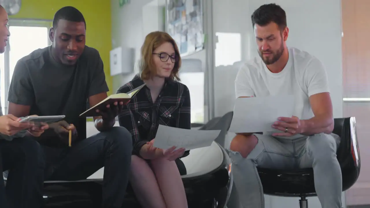 Young mixed race business team discussing over documents in modern office 4k