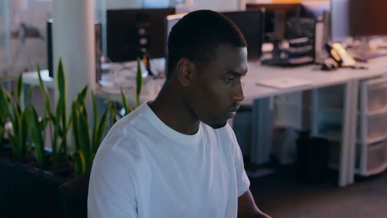 Young male executive having coffee while working on desk in modern office 4k