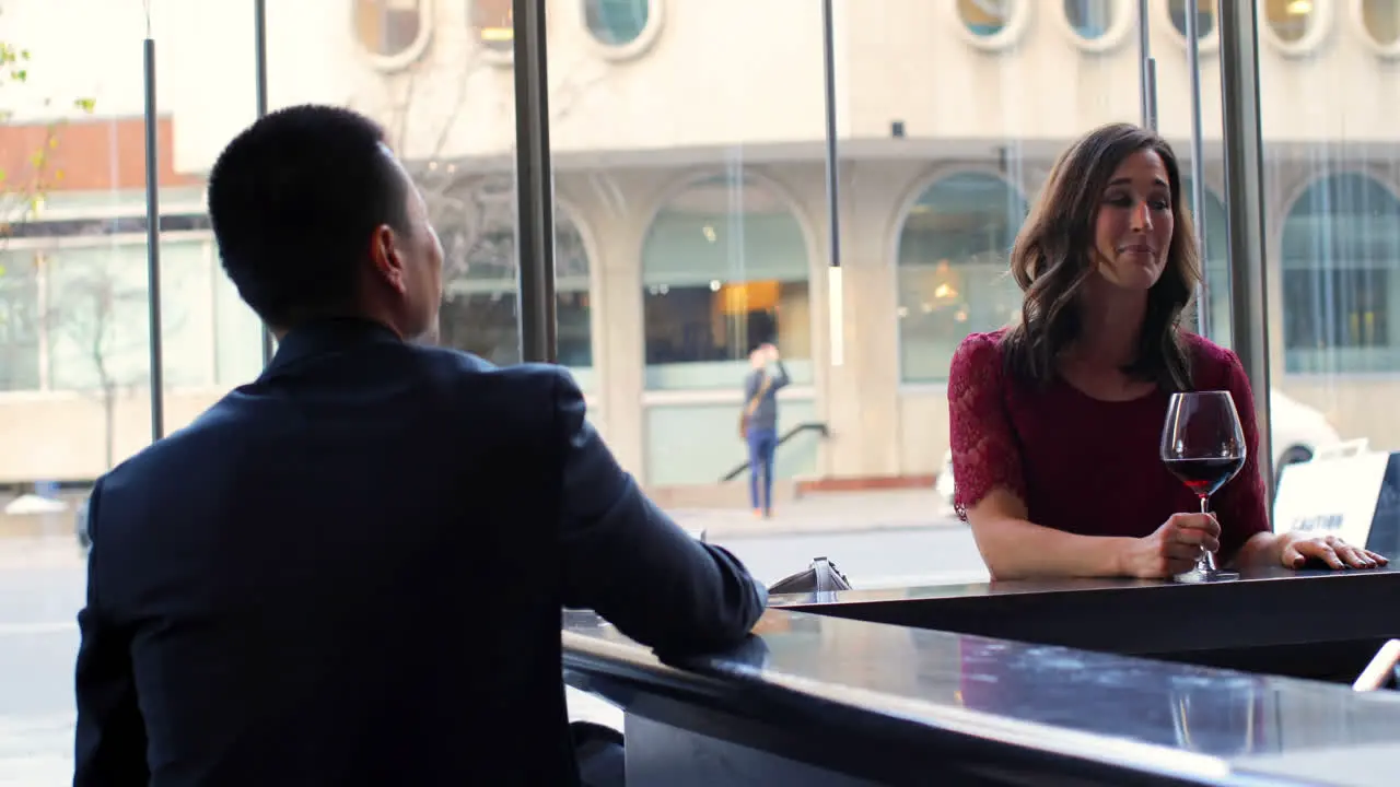 Business people interacting with each other at bar counter in hotel 4k