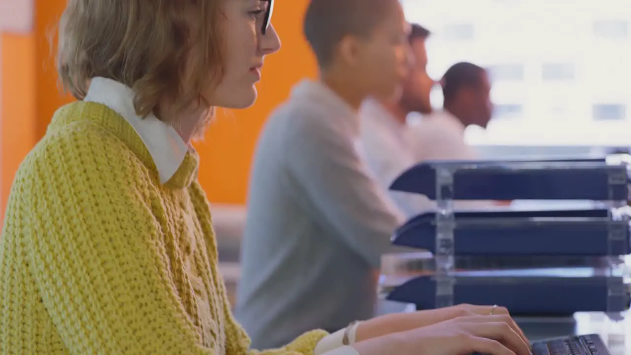 Side view of young caucasian female executives working at desk in modern office 4k