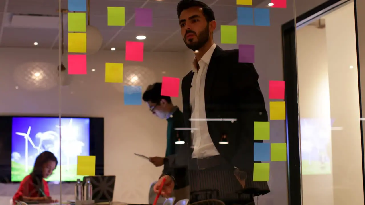 Businessman looking at sticky notes in office 4k