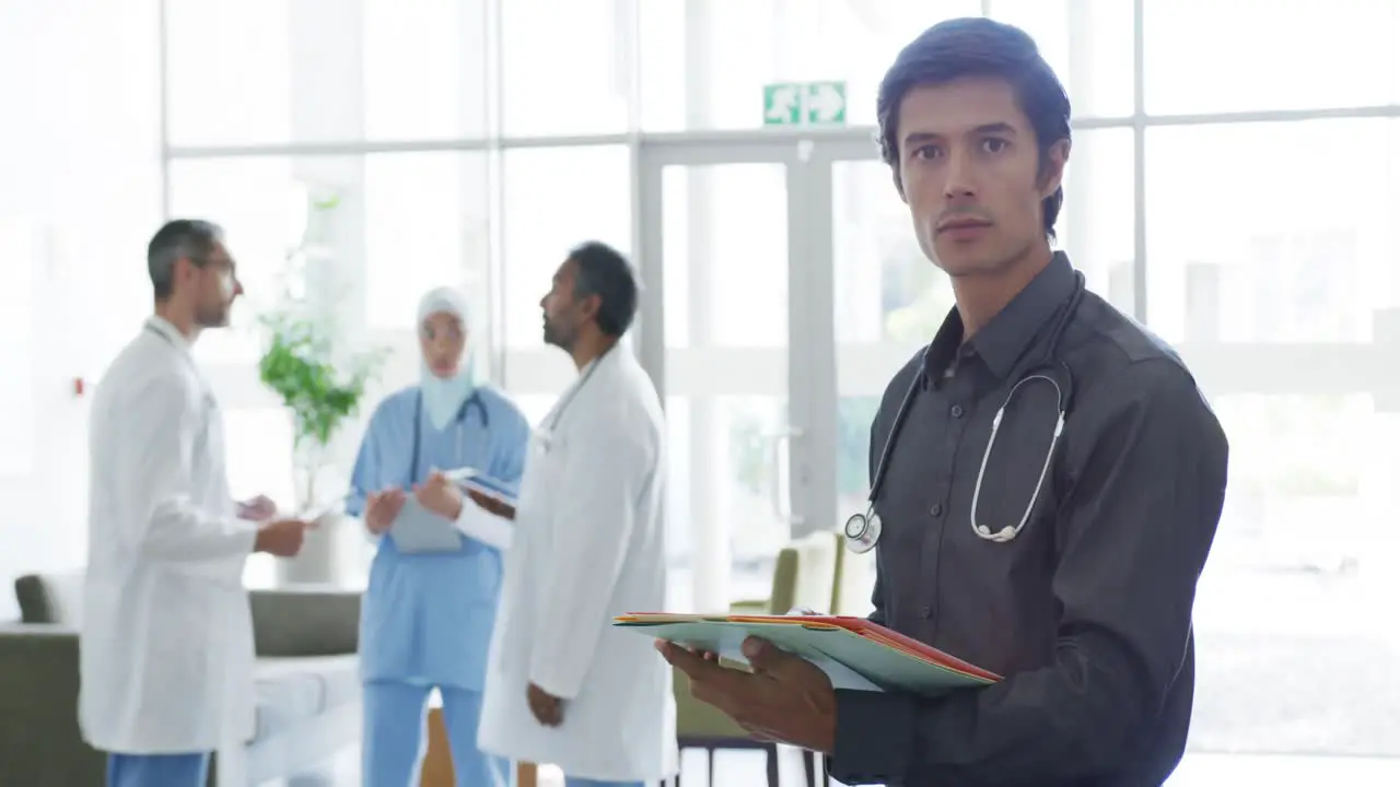 Male doctor in hospital smiles to camera 4k