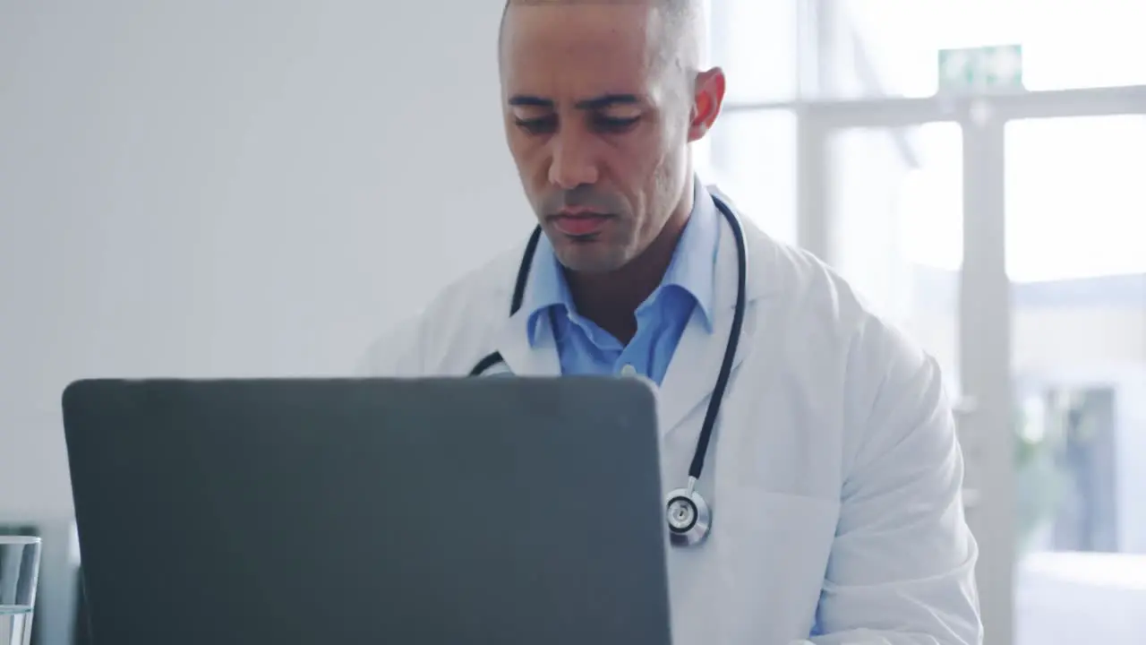 Male doctor using laptop in office 4k