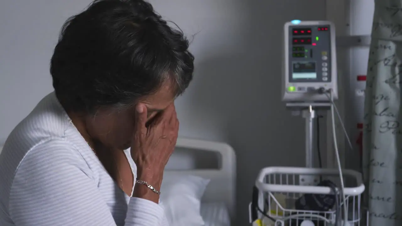 Worried woman sitting on hospital bed 4k