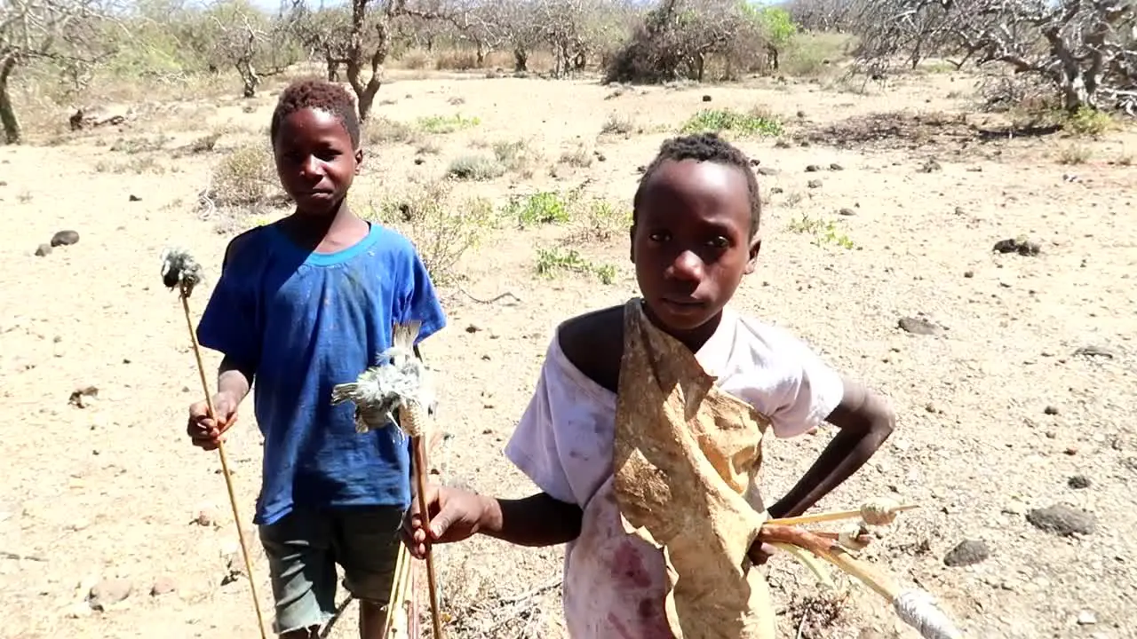 Poor African Children with birds on their arrows that they've caught to eat Slow motion