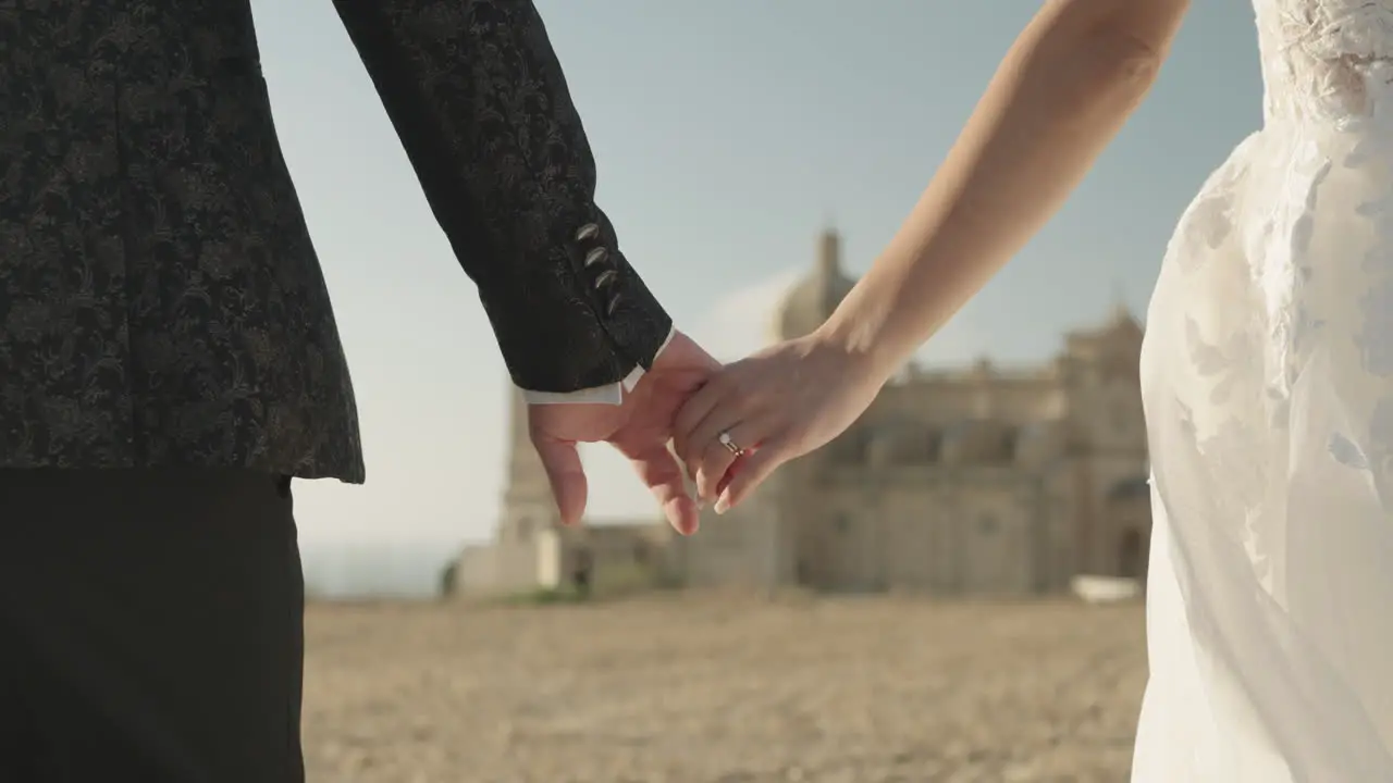 Bride and groom holding hands couple walking wedding dress church