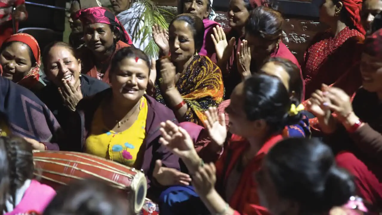 Nepali woman celebrating festival playing drums and clapping