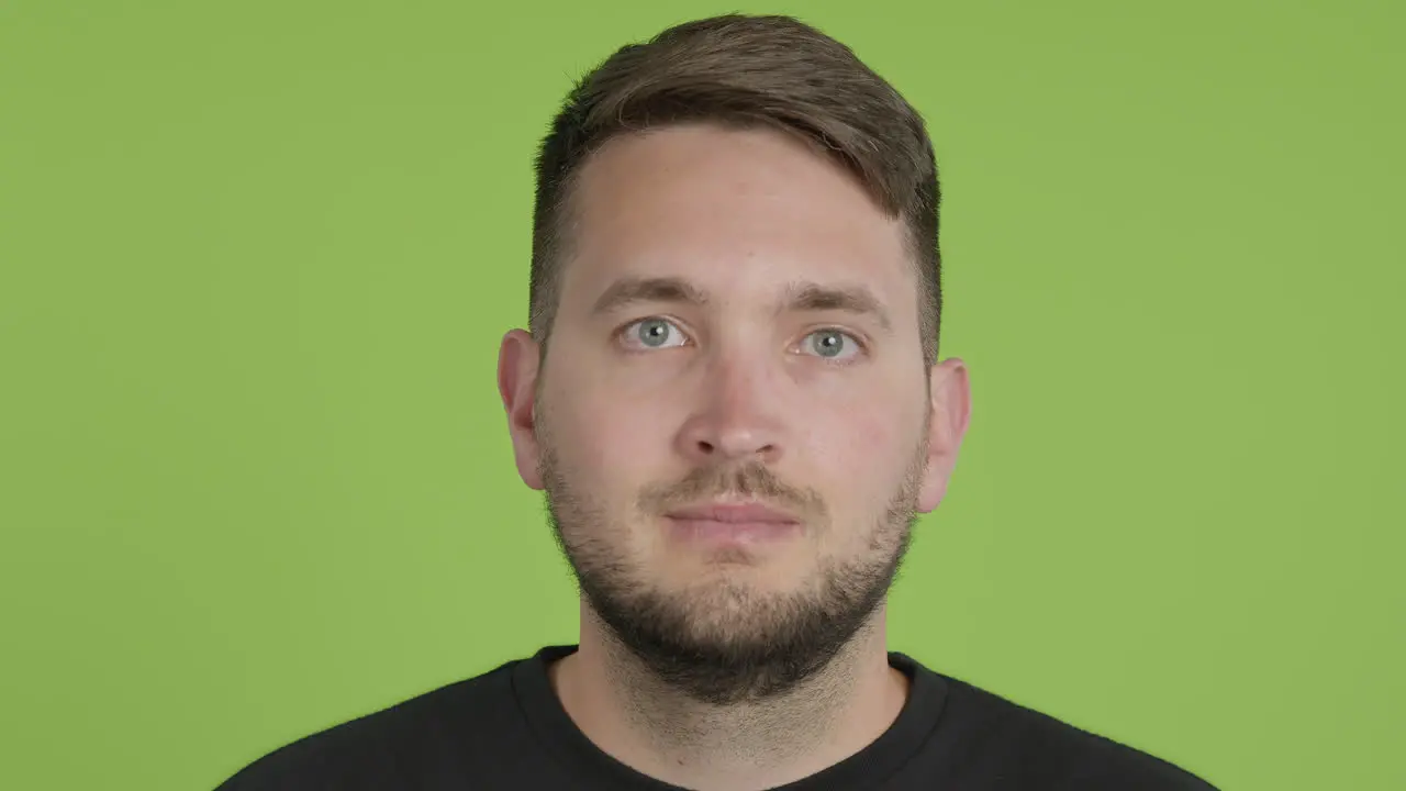 Man Removes Protective KN95 Face Mask While Looking Into Camera on Green Screen Chroma Key Close Up