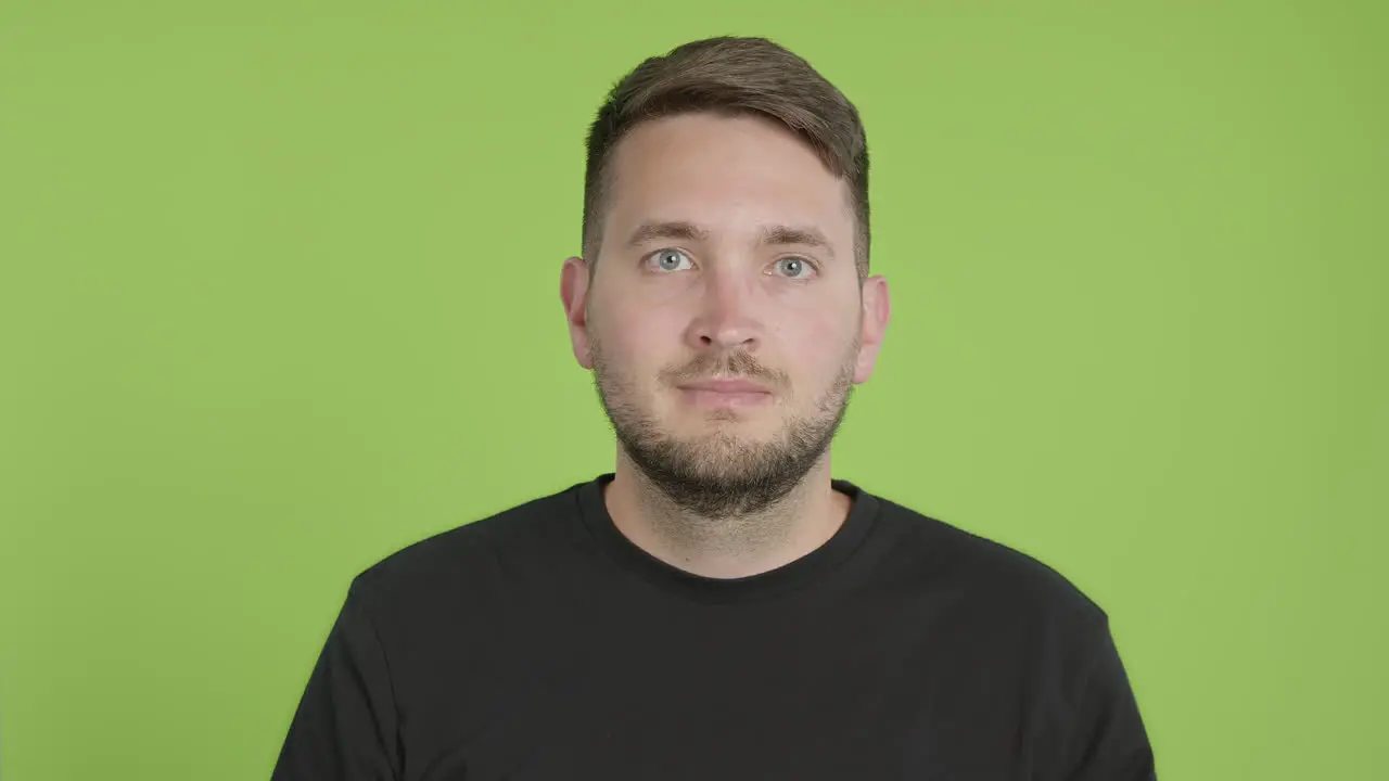 Man Removes Protective KN95 Face Mask While Looking Into Camera on Green Screen Chroma Key