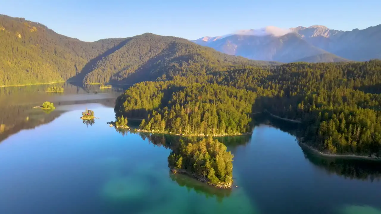 Fabulous landscape of Eibsee Lake with turquoise water in front of Zugspitze summit under sunlight