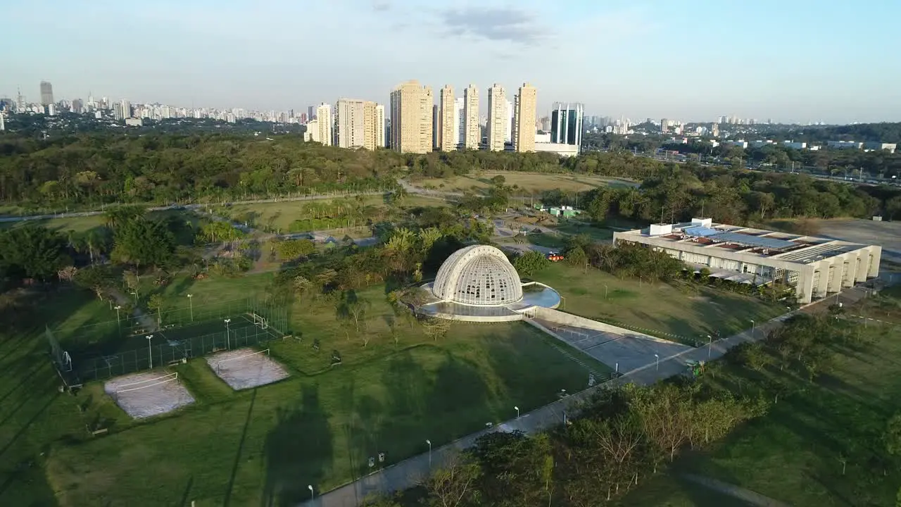 Drone flying towards a beautiful nursery located in a public park full of lush vegetation tranquility nature calm peace in 4K resolution