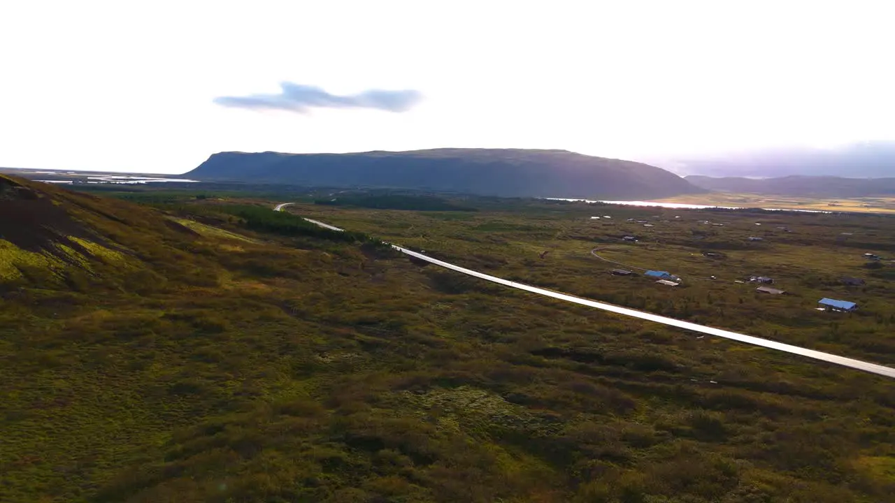 Magnificent Icelandic landscape with road F glacier in the background lake tourist driving vegetation drone shot