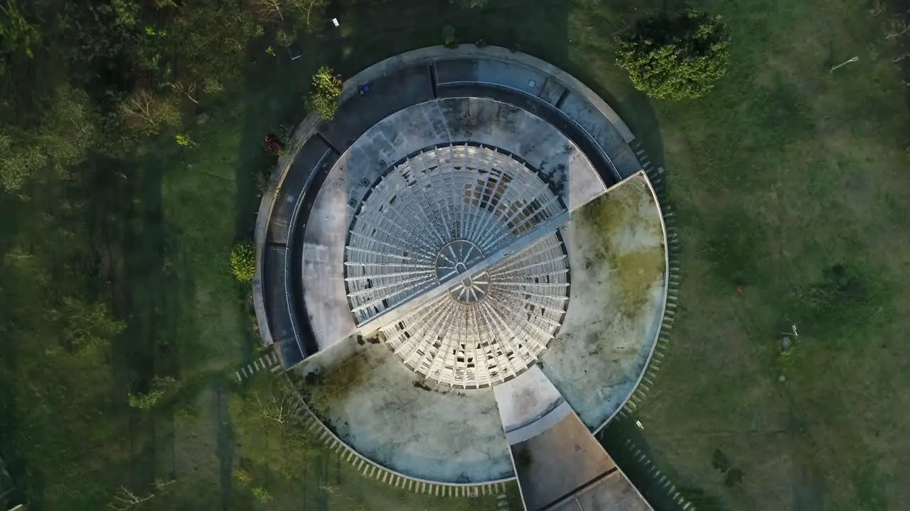 Drone shot on camera going up and spinning around orchidarium in public park full of lush vegetation tranquility nature calm peace in 4K resolution